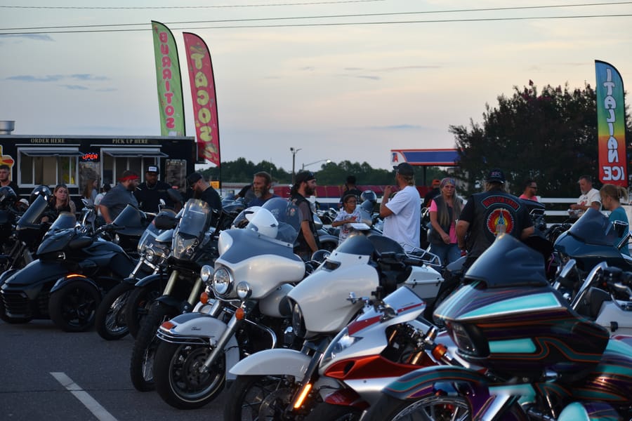 Bikes filling the lot under a dusk sky at the Eats on 601 Bike Night