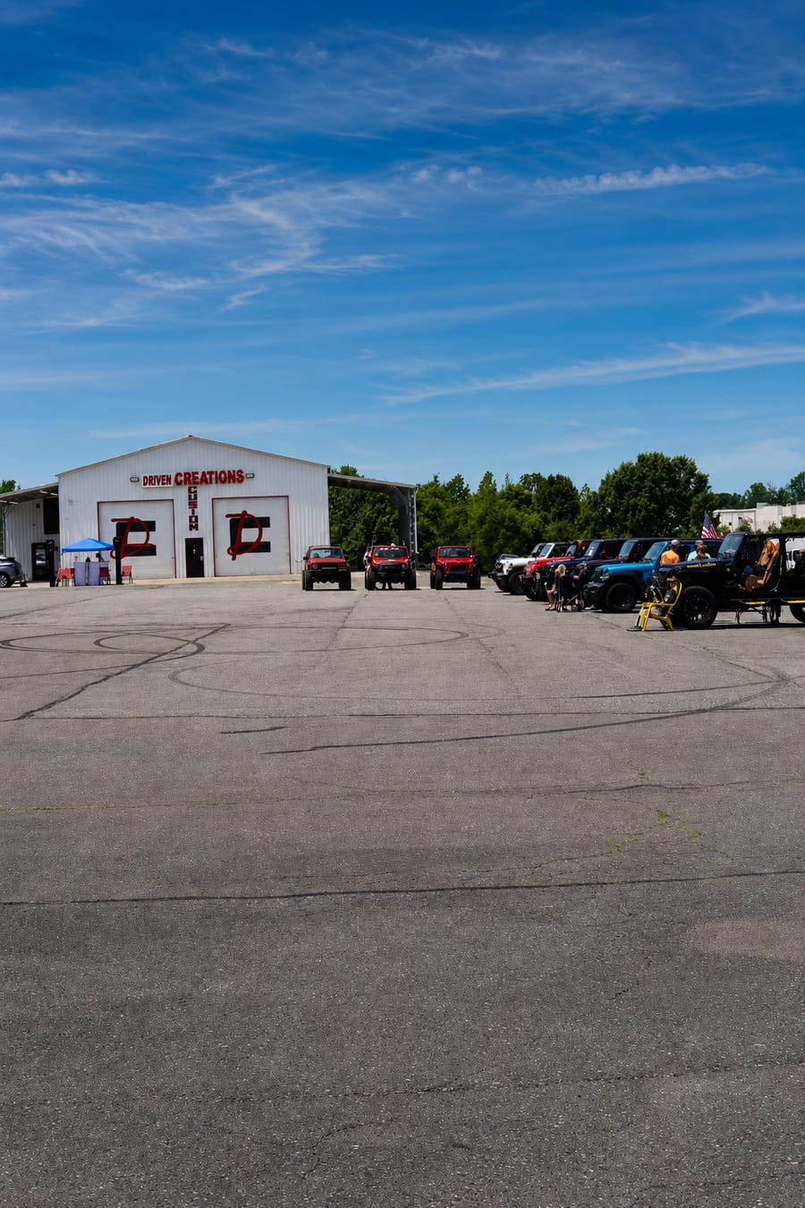 Red and silver Jeeps lined up in front of the Driven Creations shop during the Jeep Jam in Davie County, NC.