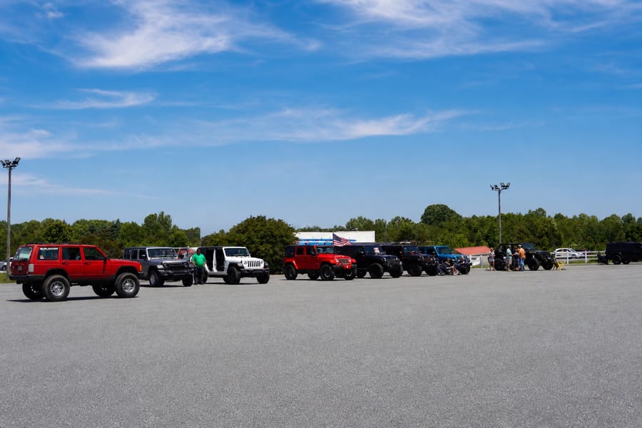 Rows of stock and lifted Jeeps under a clear North Carolina sky at the Jeep Jam meet.