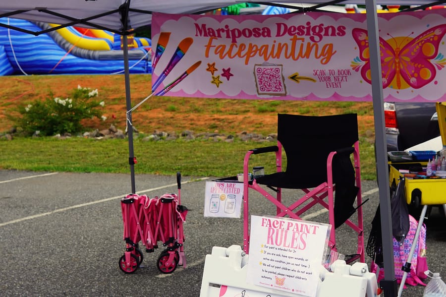 Face-painting booth with a butterfly banner