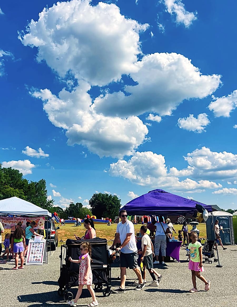 Families walking the lot at the Summer Kickoff under a big blue Carolina sky