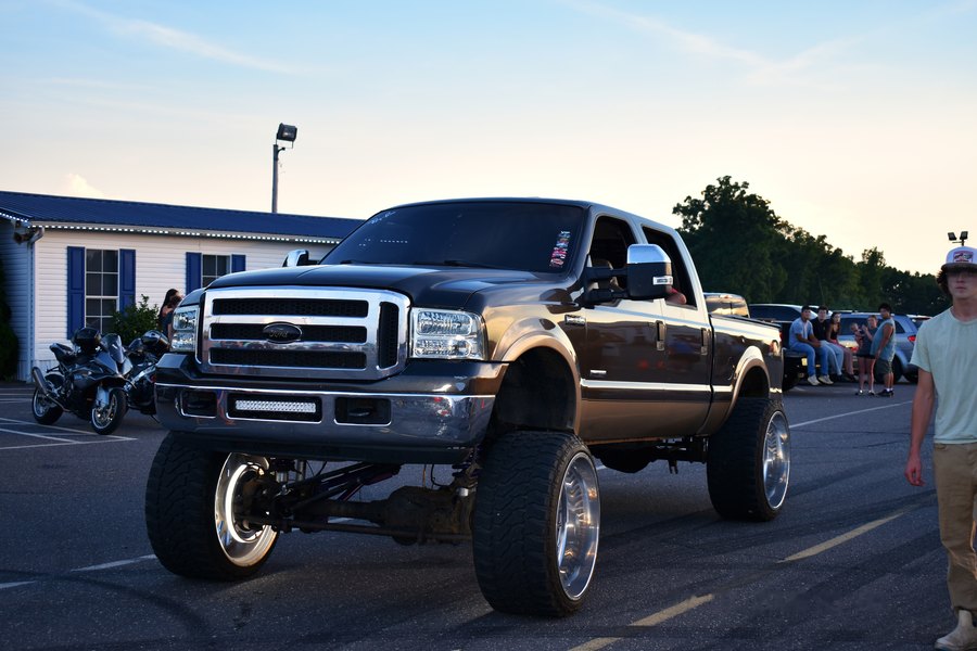 Lifted brown Ford Super Duty on polished wheels parked at the truck meet in Davie County.
