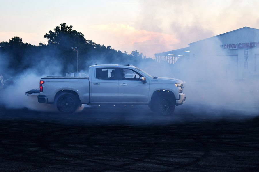 Silver truck buried in tire smoke during a burnout at the Mocksville truck meet.