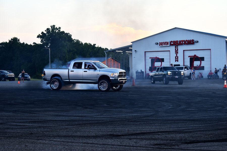 White dually pulling a burnout in front of the Driven Creations Custom shop on Highway 601.